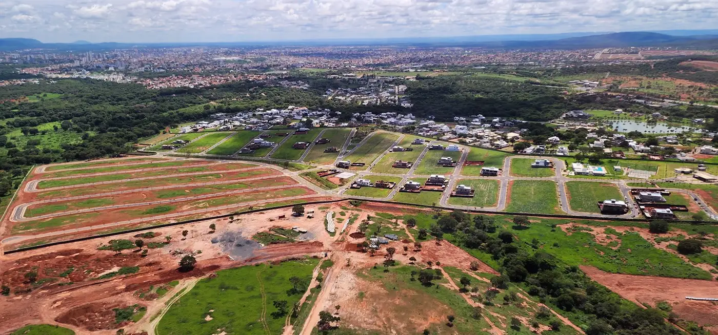 Vista aérea de loteamento em implantação ao lado de bairro já ocupado, com quadras e vias abertas