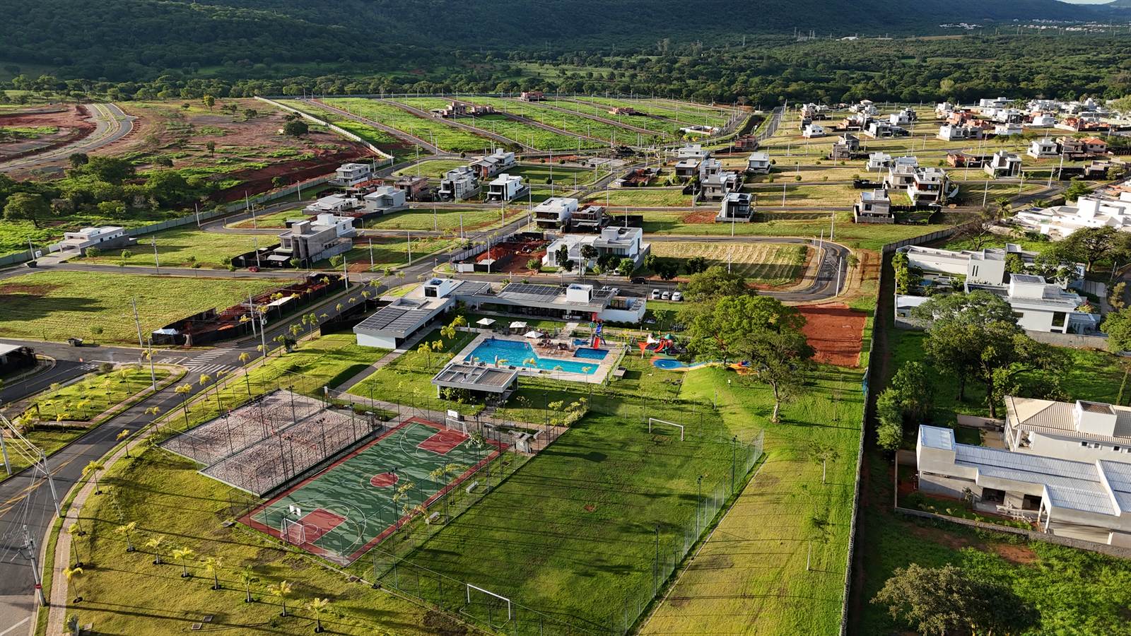 Vista aérea do Terras Alphaville com áreas de lazer e a serra ao fundo